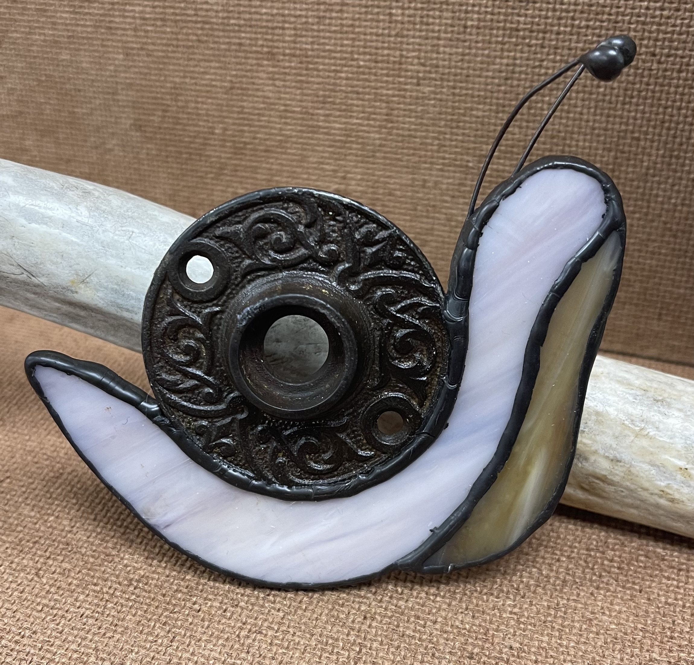 Snail with an antique doorbell plate for shell